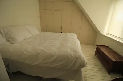 a bed in a small room with a staircase at House Akerdijk 5 persons 3 bedrooms in Badhoevedorp