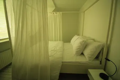 a small room with a bed with white pillows at House Akerdijk 5 persons 3 bedrooms in Badhoevedorp
