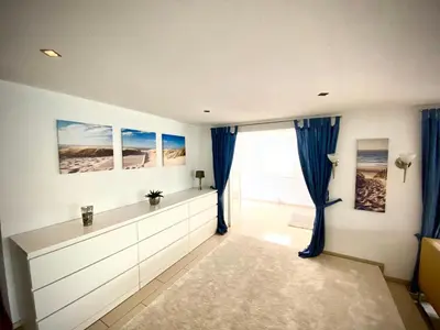 a room with blue curtains and a large window at Ferienhaus mit wundervollem Seeblick Ferienpark Vislust Ijsselmeer in Wervershoof