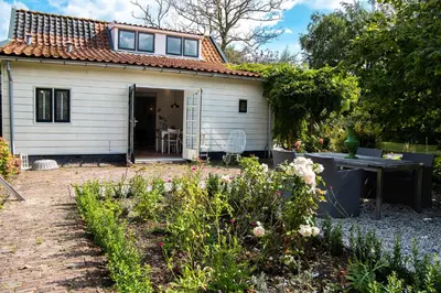 a cottage with a garden in front of it at Gastenverblijf KortVertoef in Kortenhoef