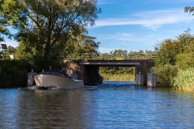 a boat on the water under a bridge at Gastenverblijf KortVertoef in Kortenhoef