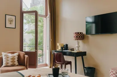 a living room with a desk and a window at Hotel Omega in Amsterdam