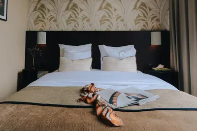 a bedroom with a bed with a book and pair of shoes at Hotel Omega in Amsterdam