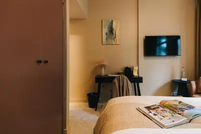 a hotel room with a bed and a desk and a television at Hotel Omega in Amsterdam