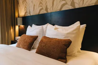 a bedroom with a bed with white pillows at Hotel Omega in Amsterdam