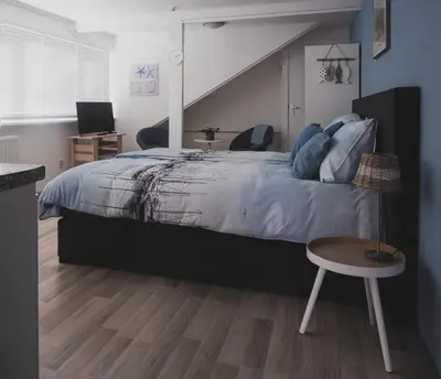 a bedroom with a large bed and a table at B&B Het Ruime Sop in Wassenaar