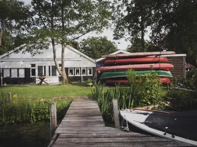 a boat sitting on a dock next to a house at B&B Het Ruime Sop in Wassenaar