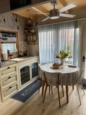 a kitchen with a table and a ceiling fan at Tinyhouse Woody at the Water in Zaandam