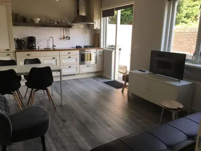a kitchen with a couch and a table with a tv at Vakantiewoning Van der Meer, Egmond aan Zee in Egmond aan Zee