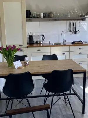 a kitchen with a wooden table and four chairs at Vakantiewoning Van der Meer, Egmond aan Zee in Egmond aan Zee