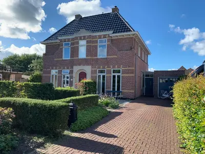 a red brick house with a black roof at Jagershof in Egmond aan den Hoef