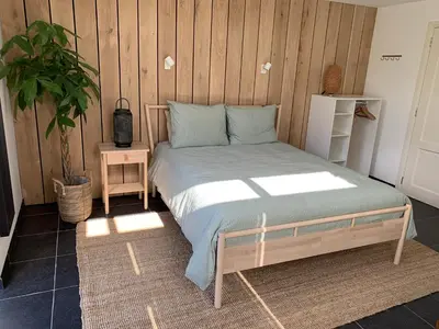 a bed in a room with a wooden wall at Jagershof in Egmond aan den Hoef