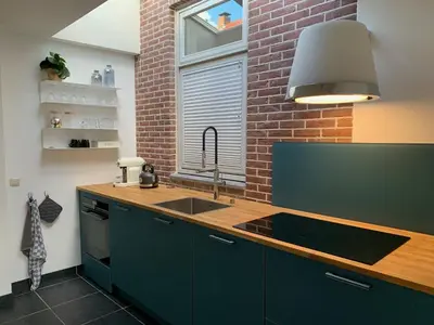 a kitchen with a sink and a brick wall at Jagershof in Egmond aan den Hoef