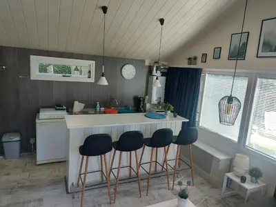 a kitchen with a counter and stools at a bar at Cottage 322 in Dirkshorn