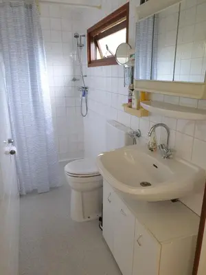 a white bathroom with a toilet and a sink at Cottage 322 in Dirkshorn