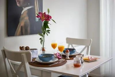 a table with two glasses of orange juice and a flower on it at Bed & Breakfast De Oude Kapel in Driebergen