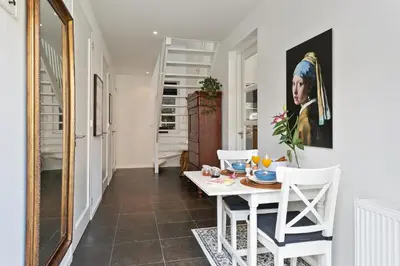a dining room with a table and a painting of a woman at Bed & Breakfast De Oude Kapel in Driebergen