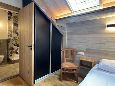 a bedroom with a bed and a chair and a window at Pakasa in Leiden