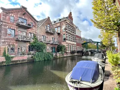 a boat parked in a canal in front of buildings at Pakasa in Leiden