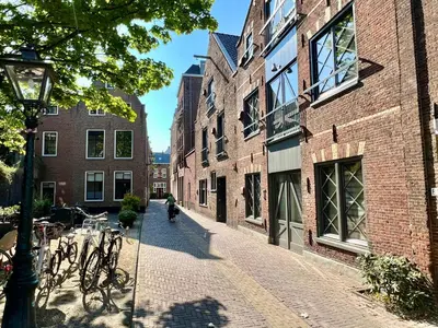 a person riding a bike down a street with buildings at Pakasa in Leiden