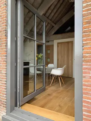 a room with glass doors and a table with chairs at Pakasa in Leiden