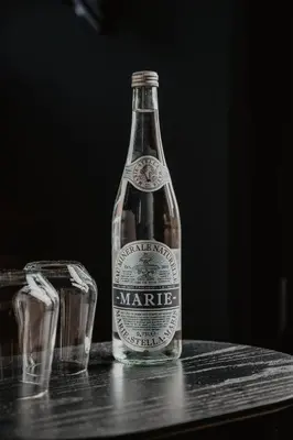 a bottle of marmite sitting on a table with two glasses at The Nox Hotel in Utrecht