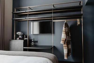 a bedroom with a bed with a tv on a wall at The Nox Hotel in Utrecht