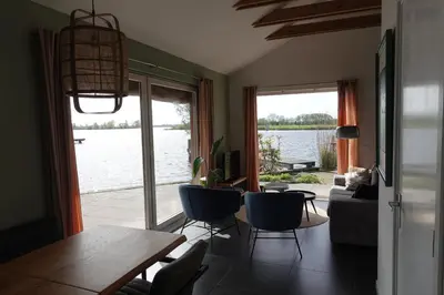 a living room with a view of the water at Vakantie huis aan het water in Rijpwetering