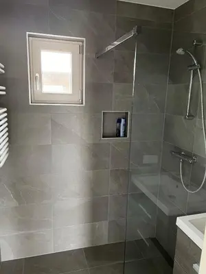 a bathroom with a shower with a glass door at Vakantie huis aan het water in Rijpwetering