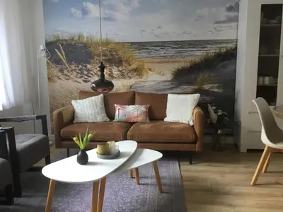 a living room with a couch and a beach mural at De Linden in Egmond aan Zee