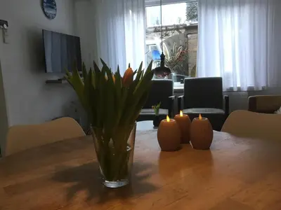 a vase with flowers and candles on a table at De Linden in Egmond aan Zee