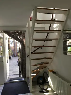 a spiral staircase in a house with a hallway at De Linden in Egmond aan Zee