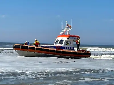 a boat in the ocean with people on it at De Linden in Egmond aan Zee