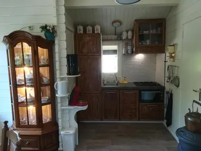 a kitchen with wooden cabinets and a sink at het Uylennest, uniek en goedkoop! in Hem