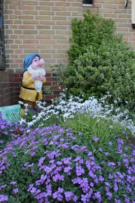 a statue of a person in a garden with flowers at het Uylennest, uniek en goedkoop! in Hem
