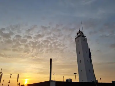 a white lighthouse with the sunset in the background at cottage near the beach in the center.**** in Noordwijk aan Zee
