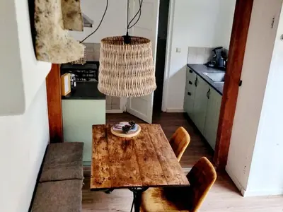 a table and chairs in a kitchen with a chandelier at cottage near the beach in the center.**** in Noordwijk aan Zee