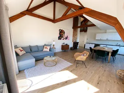 a living room with a blue couch and a table at Luxurious historical Loft close to the beach! in Wassenaar