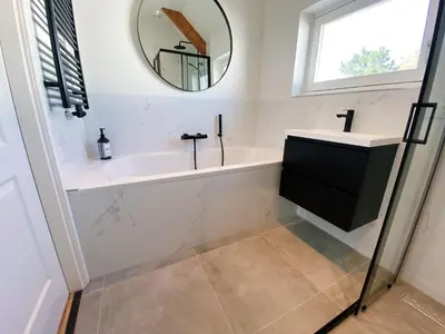 a bathroom with a sink and a mirror at Luxurious historical Loft close to the beach! in Wassenaar