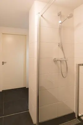 a shower with a glass door in a bathroom at Alkmaar City Apartments in Alkmaar