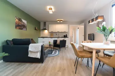a living room and dining room with a couch and a table at Alkmaar City Apartments in Alkmaar