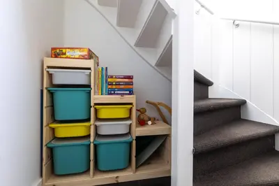 a stair room with a shelf with bins at Kustlijn vakantiewoning in Egmond aan den Hoef