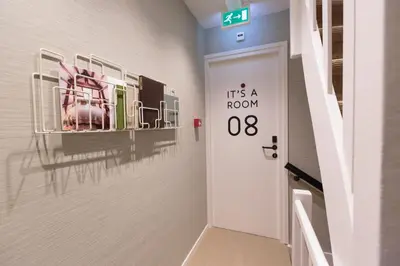 a hallway with a door with a sign that reads its at Hotel Dwars in Amsterdam