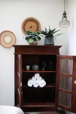 a wooden shelf with towels and a plant on it at Hotel Dwars in Amsterdam