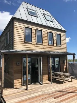 a house with a gambrel roof on a deck at Kaap Hoorn Club Bed en Breakfast in Hoorn