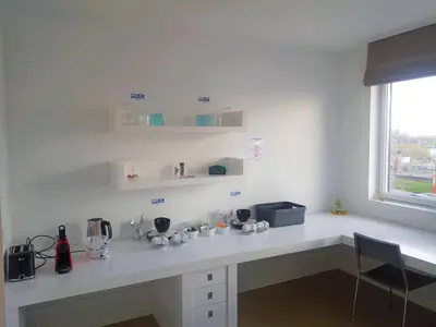 a white kitchen with a counter and a window at Kaap Hoorn Club Bed en Breakfast in Hoorn