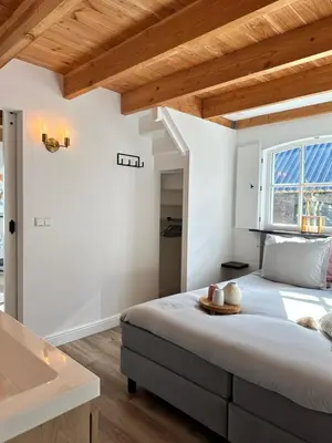a bedroom with a large bed and a sink at Noxem b&b in Boesingheliede