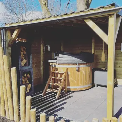 a wooden cabin with a hot tub in it at Noxem b&b in Boesingheliede
