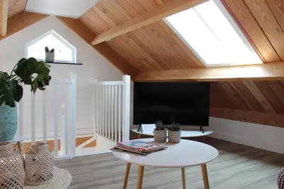 a living room with a white table and a tv at Noxem b&b in Boesingheliede
