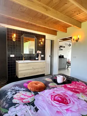 a bathroom with a large bed with flowers on it at Noxem b&b in Boesingheliede